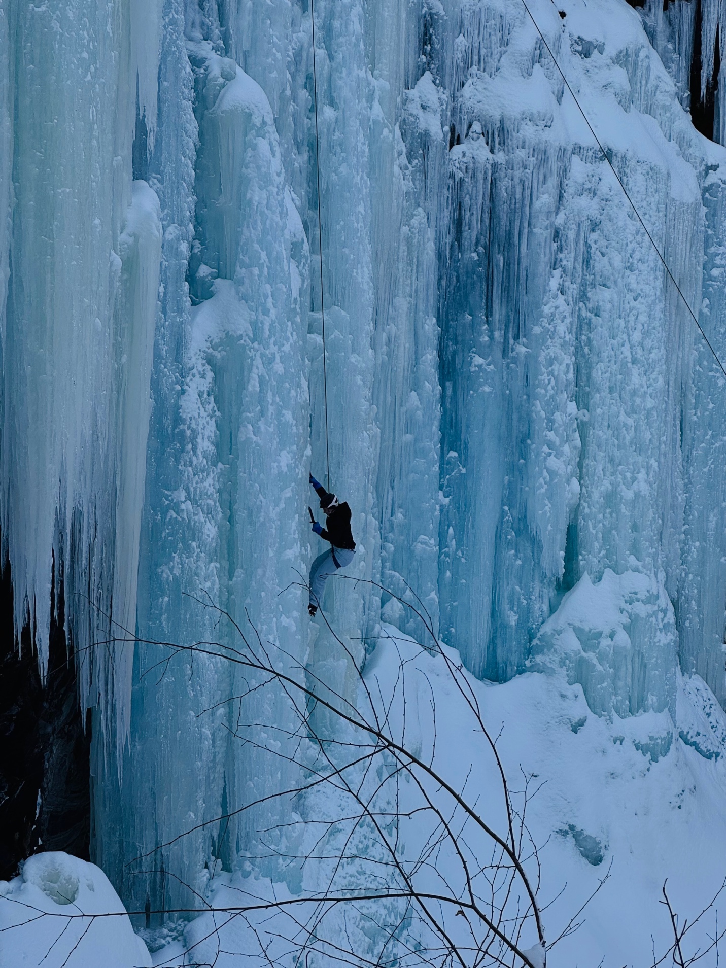 A climber ascending a frozen waterfall