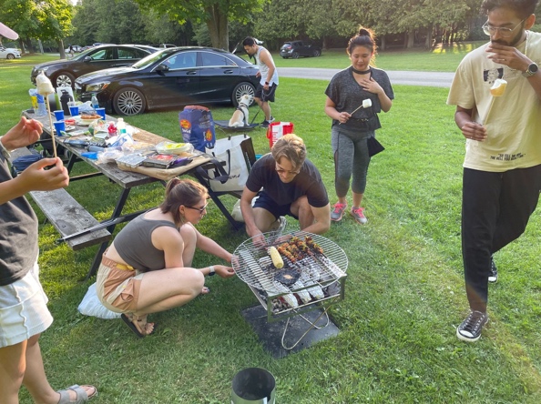 A summer barbecue with friends at a park picnic table